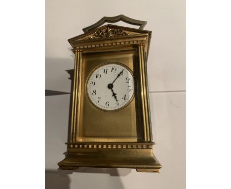 A BRASS CARRIAGE CLOCK WITH  GABLED TOP WITH GLASS VIEWING PANE, FRENCH MECHANICAL MOVEMENT AND KEY 