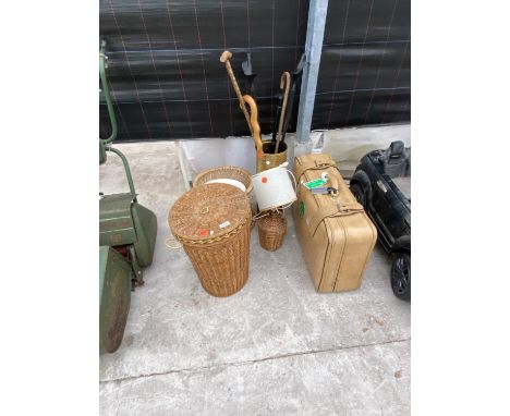 TWO WICKER BASKETS, A BRASS STICK STAND AND STICKS, A TABLE LAMP AND A SUITCASE 