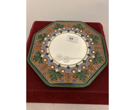 A SMALL CIRCULAR MIRROR WITH A DECORATED CERAMIC SURROUND 