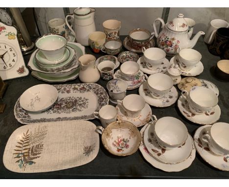 AN ASSORTMENT OF CERAMIC TEA SERVICE WARE TO INCLUDE CUPS AND SAUCERS AND VARIOUS JUGS 