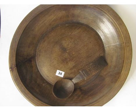 A 19th century Provincial turned treen bowl with a carved treen ladle, 18 diameter
