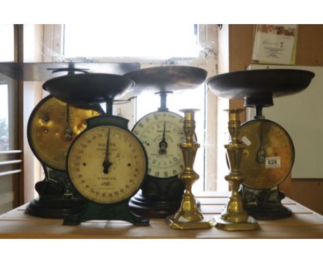 Four vintage Salter scales with pans and a pair of brass candlesticks.