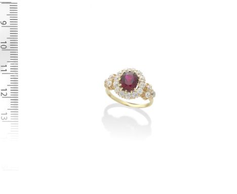 RUBY AND DIAMOND CLUSTER RINGThe oval-cut ruby, weighing 2.48 carats, within a surround of old brilliant-cut diamonds, betwee