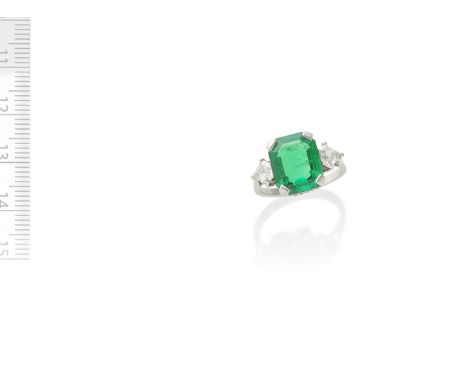 EMERALD AND DIAMOND RINGThe step-cut emerald, weighing 4.38 carats, between pentagonal-shaped diamond shoulders, ring size MF