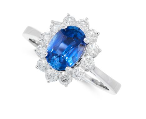 A SAPPHIRE AND DIAMOND CLUSTER RING in 18ct white gold set with an oval cut sapphire of 2.20 carats in a cluster of round cut