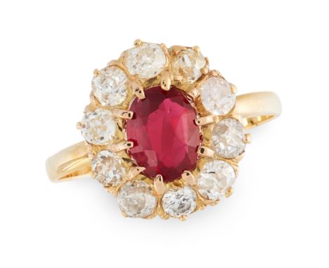 A RUBY AND DIAMOND CLUSTER RING in yellow gold, set with an oval cut ruby of 0.84 carats in a border of old and round cut dia