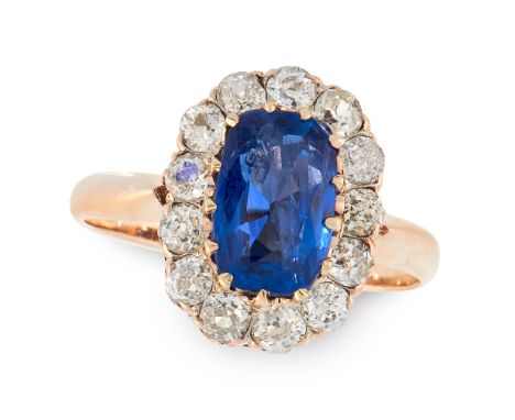 A BURMA NO HEAT SAPPHIRE AND DIAMOND CLUSTER RING in yellow gold, set with a cushion cut sapphire of 2.28 carats in a border 