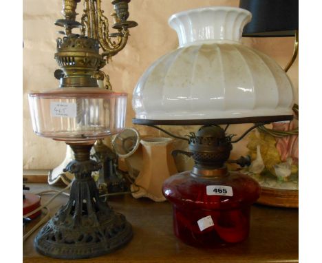 A Victorian table oil lamp with pink glass reservoir and cast iron base - sold with the reservoir, burner and shade of anothe