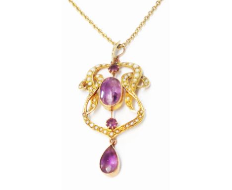 An Edwardian yellow metal ornate seed pearl and amethyst set open scroll pendant on chain
