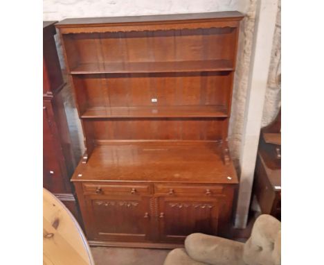 A 1.22m early 20th Century oak two part dresser with two shelf open plate rack over a base with two frieze drawers and pair o