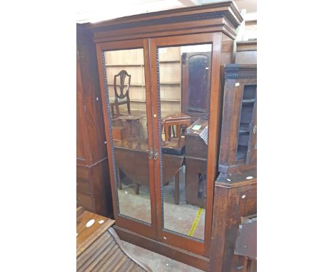 A 1.17m 19th Century mahogany double wardrobe with moulded cornice and applied decoration, hanging space and shelf enclosed b