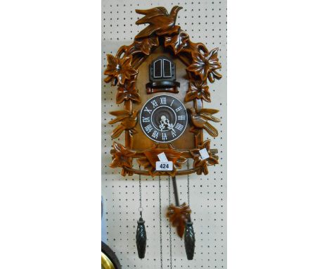 A modern wood effect cuckoo wall clock with battery movement