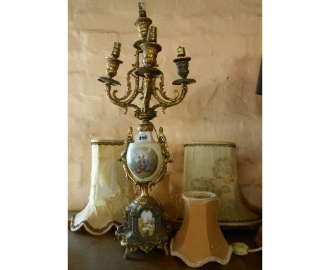 An ornate porcelain and brassed spelter five branch candelabra form table lamp