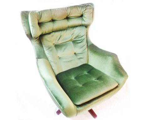 A vintage Parker Knoll swivel egg chair, upholstered in green button back velour, set on polished wood legs
