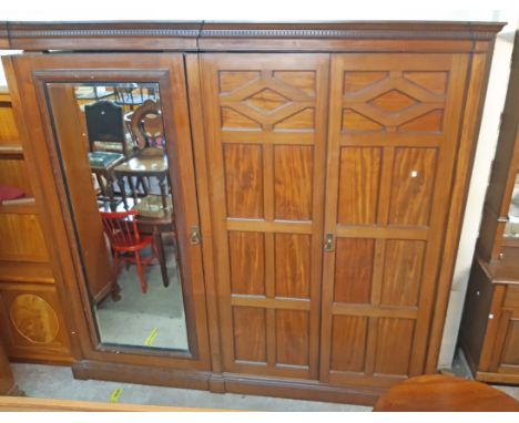 A 2.45m late Victorian mahogany triple wardrobe with moulded dentil cornice, slide and drawers enclosed by a pair of panelled