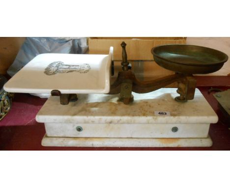 A set of balance scales with ceramic pan and slab marble base