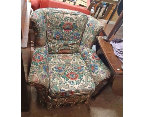 A vintage cottage wingback armchair with original upholstery and later vase and flowers pattern fitted cover and cushions