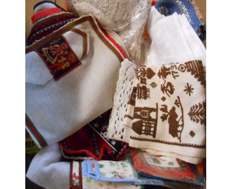 A crate containing assorted vintage embroidered and other linen materials