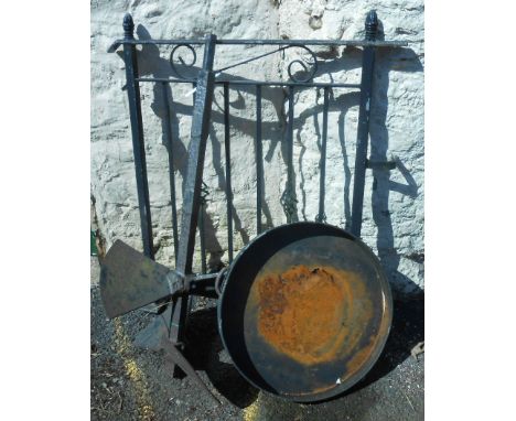 A vintage industrial mixing paddle, a metal balustrade, and a metal two handled shallow pan