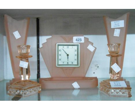 An Art Deco moulded pink glass clock garniture with simple timepiece movement - sold with a pair of small moulded glass dress