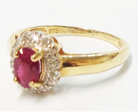 An import marked 375 gold ring, set with small central oval ruby within a diamond border