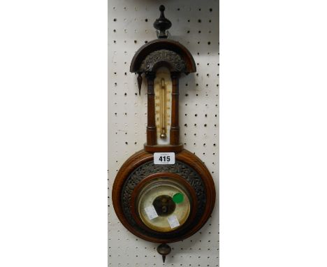 A late Victorian oak cased wall barometer/thermometer with visible aneroid works - one finial a/f