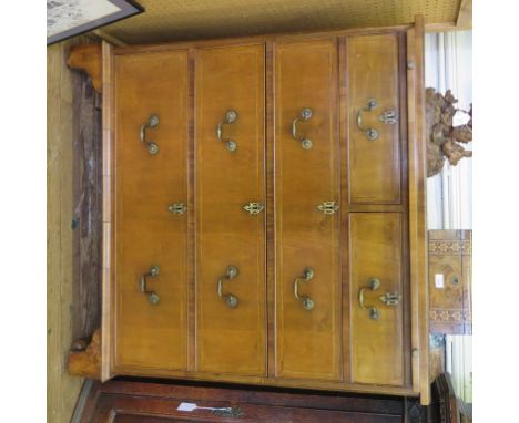 A George II style crossbanded walnut chest of drawers, by Biggs of Maidenhead, with brush slide over two short and three long