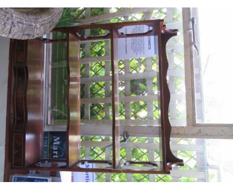 A mahogany wall shelf, the three shaped shelves over three drawers on fret carved supports, 69cm wide