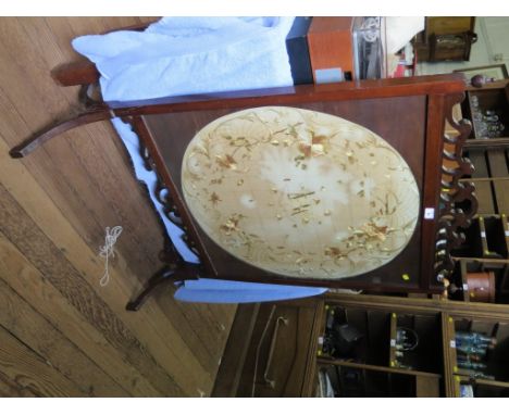 An Edwardian firescreen, the fret carved top over a circular silk panel embroidered with flowers, monogram and dated April 19