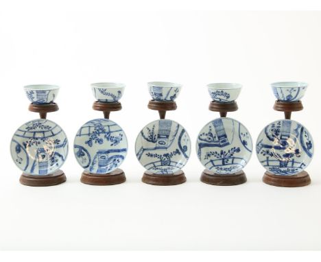Serie van 5 blauw-wit porseleinen&nbsp;kop-en-schotels met afbeelding van bloeiende heesters in perken, China, Kangxi-periode