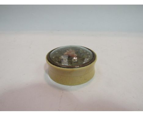 A 19th Century ivory patch box with highly ornate floral decoration under glass, 5cm diameter