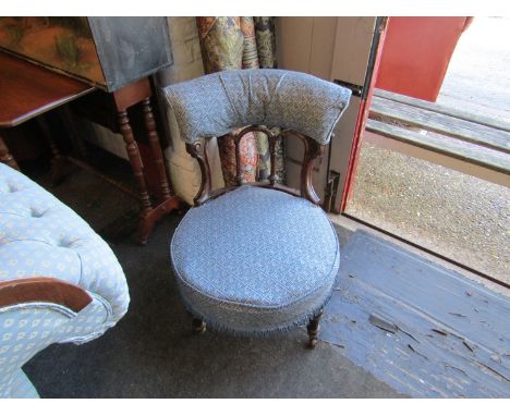A Victorian walnut bedroom chair with blue upholstery on ceramic castors 