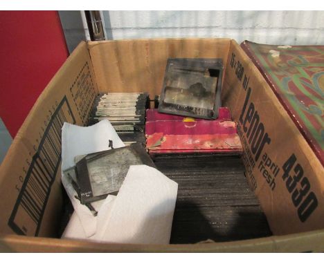 A box containing glass negatives and magic lantern slides including South African and family portrait examples