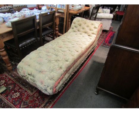 A Victorian deep button back chaise lounge with pale green and coral silk foliate upholstery, toning fringing set to squat tu