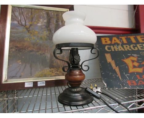 A table lamp as an oil lamp with white glass shade