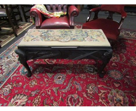 A duet piano stool with floral woven tapestry upholstery and carved ebonised base, 97cm long x 52cm tall