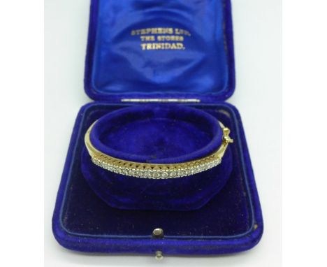 A 9ct gold bangle set with twenty-one diamonds, 11.1g