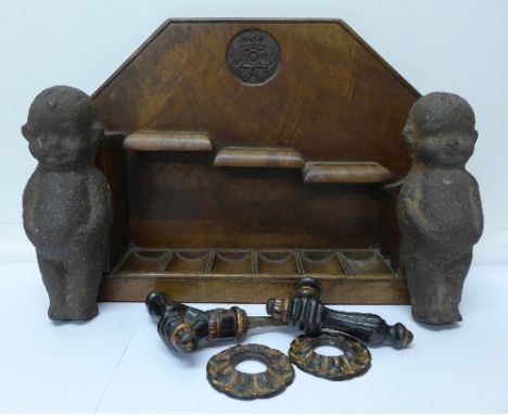 A mahogany pipe rack with carved Royal Artillery 'badge', two heavy cast figures of babies and a cast door handle in the form