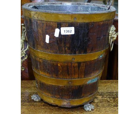 A Victorian coopered oak bucket, with metal liner, brass lion mask ring handles, on lion paw feet, H34cm 
