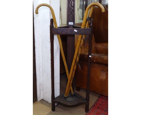 An Art Nouveau oak triangular stick stand and 3 walking sticks 