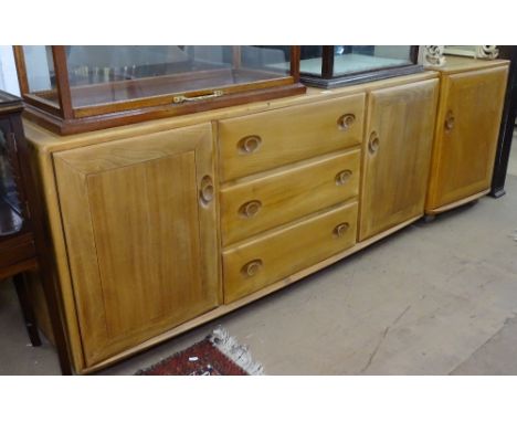 An Ercol light elm low sideboard, with fitted drawers and cupboards, and a matching single door cabinet, sideboard length 155