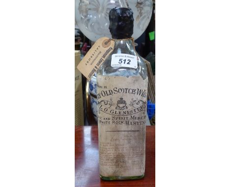 A bottle of very old Scotch Whisky, retailed in Hastings, broken seal 