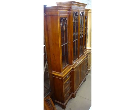 A reproduction yew wood breakfront 2-section bookcase, with 4 lattice glazed doors above drawers and cupboards, on bracket fe