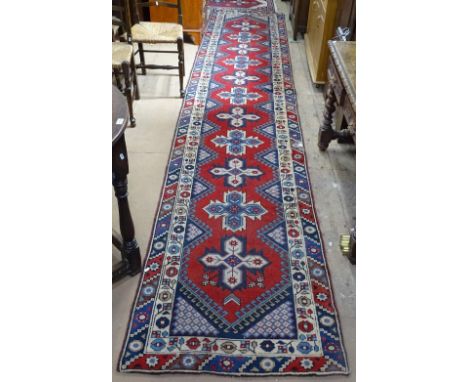 A red ground Turkish runner, with 2 borders and symmetrical pattern, and a similar small mat, runner length 466cm, W90cm 