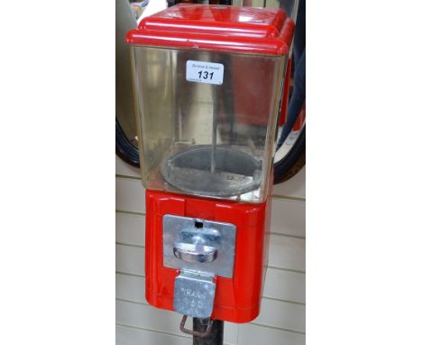 A Vintage red plastic bubblegum dispensing machine, on cast-iron stand, height 54.5" 