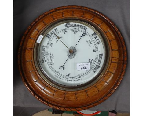 A carved oak-cased aneroid barometer, diameter 13" 