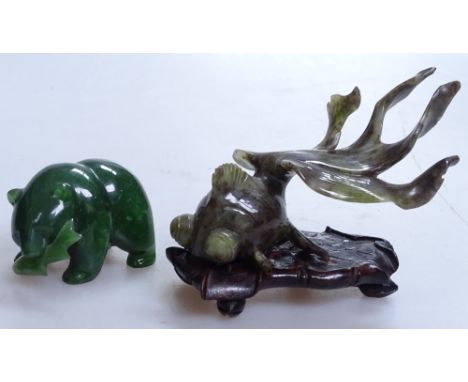 A carved Oriental jade fish on fitted stand, length 3.5" overall, and a carved green-stone bear with fish 