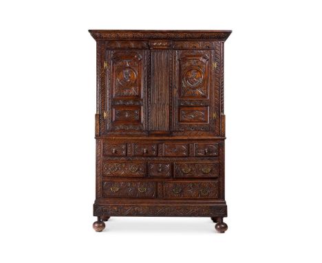 A LARGE CONTINENTAL CARVED OAK PRESS CUPBOARD  POSSIBLY NORTHERN FRANCE, 19TH/ EARLY 20TH CENTURY  With a carved overhanging 