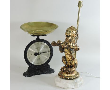 A gilt table lamp, in the form of a lion, together with a set of scales, 32cm high