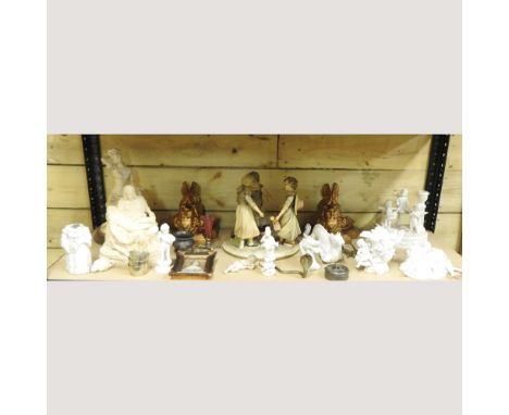 A shelf of decorative china, to include white glazed figure groups and a pair of gilt wall brackets